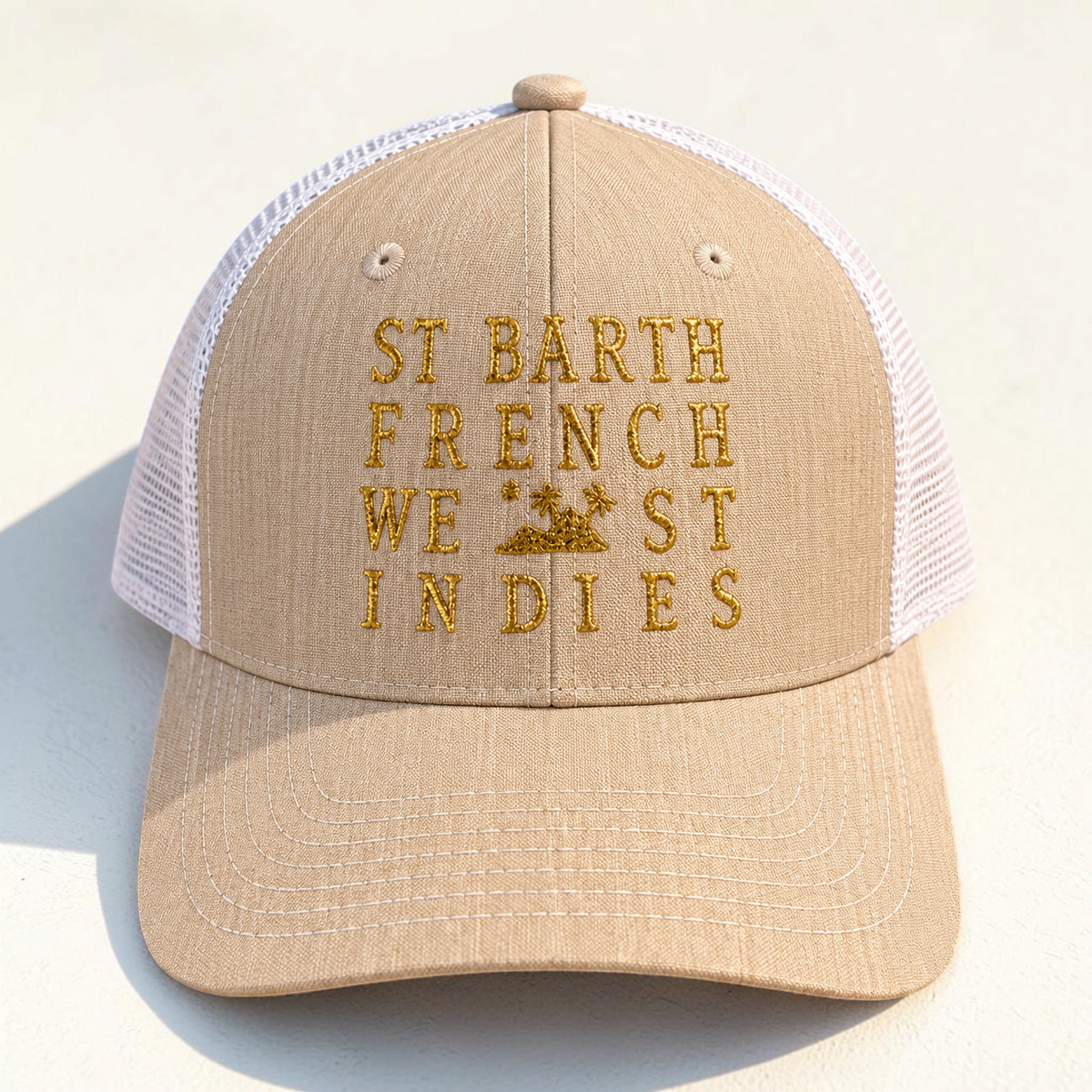 Casquette de baseball St Barth French West Indies beige avec filet blanc, posée sur du sable fin.