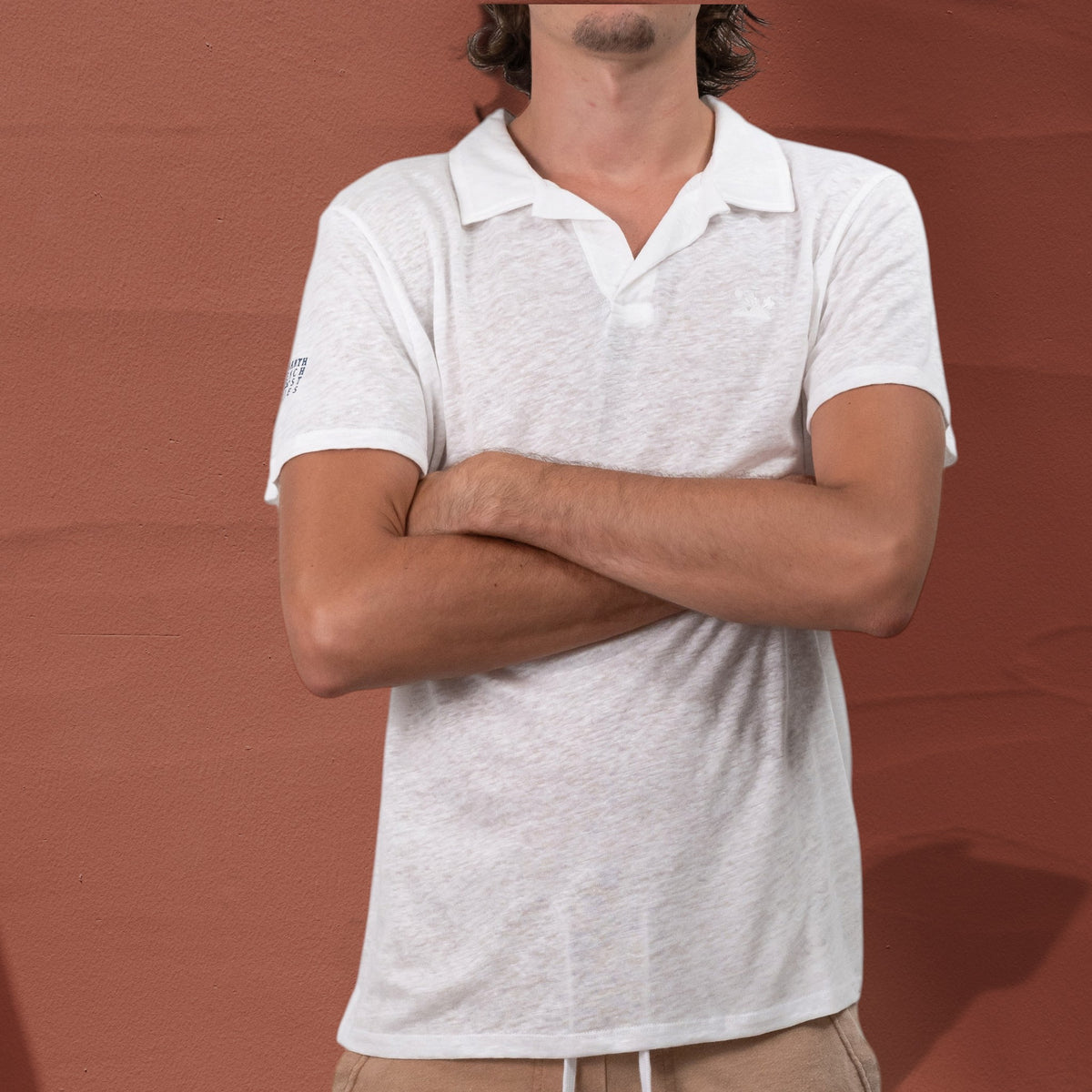 Homme portant un polo St Barth French West Indies blanc en jersey de lin avec broderie ton sur ton sur la poitrine