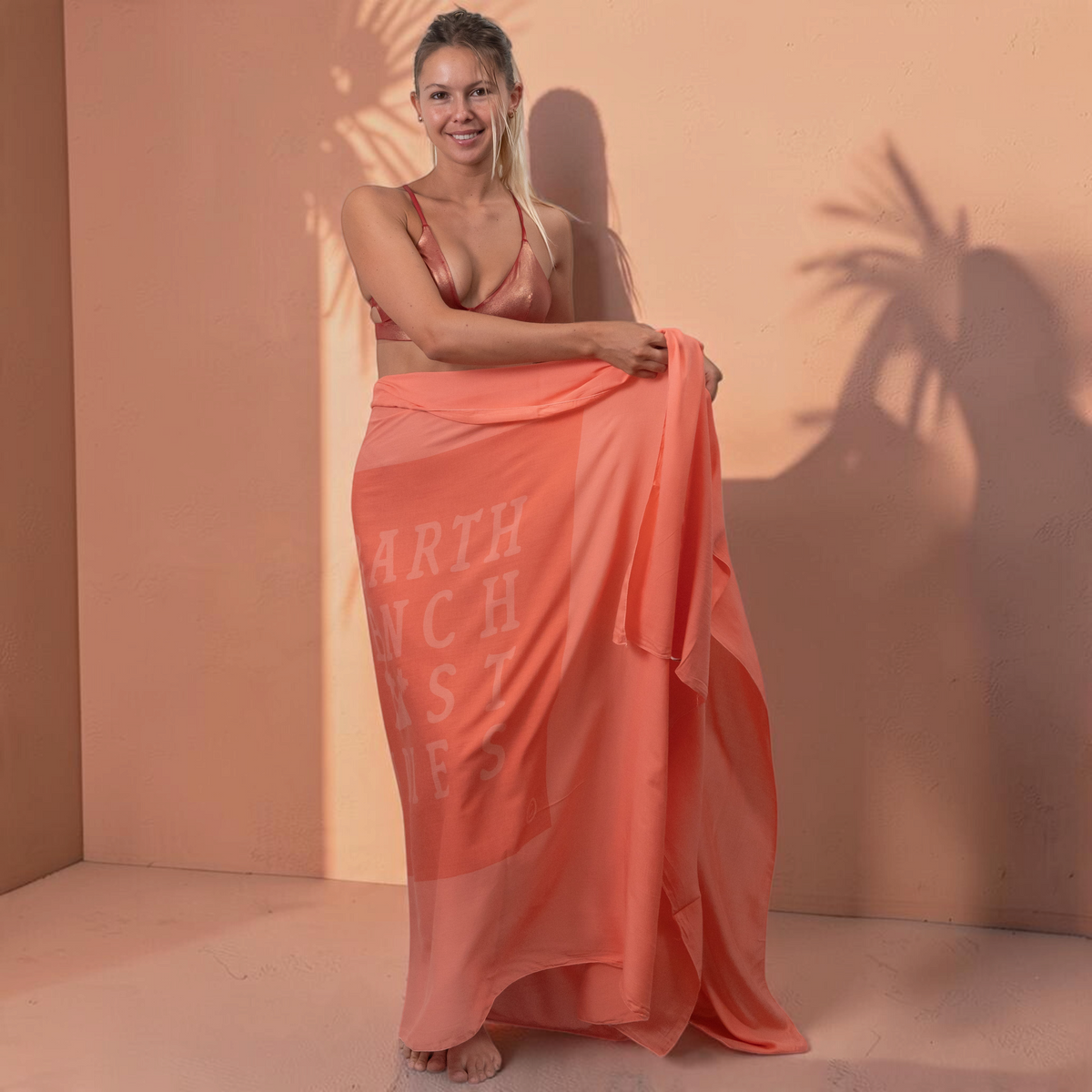 Femme portant un paréo St Barth French West Indies en voile de coton corail léger et doux, idéal pour la plage.