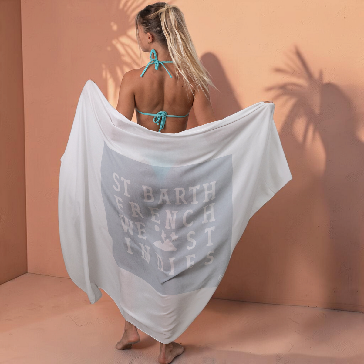 Femme portant un paréo St Barth French West Indies blanc en voile de rayonne doux avec logo imprimé au dos