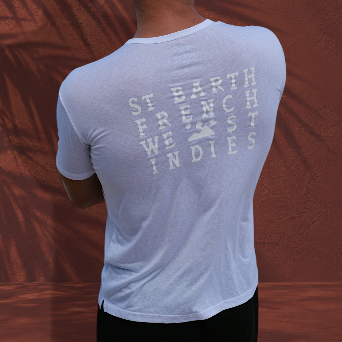T-shirt blanc St Barth French West Indies en mΓ©lange lyocell et polyester ultra-doux, vue de dos sur fond terracotta.