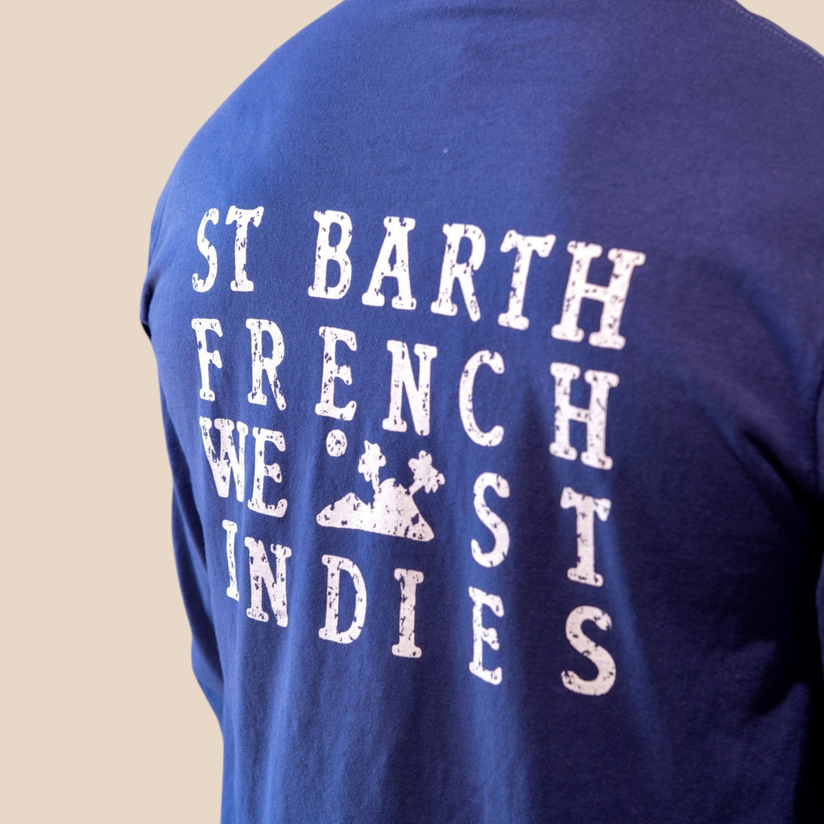 Homme portant un t-shirt bleu St Barth French West Indies à manches longues avec logo blanc imprimé au dos