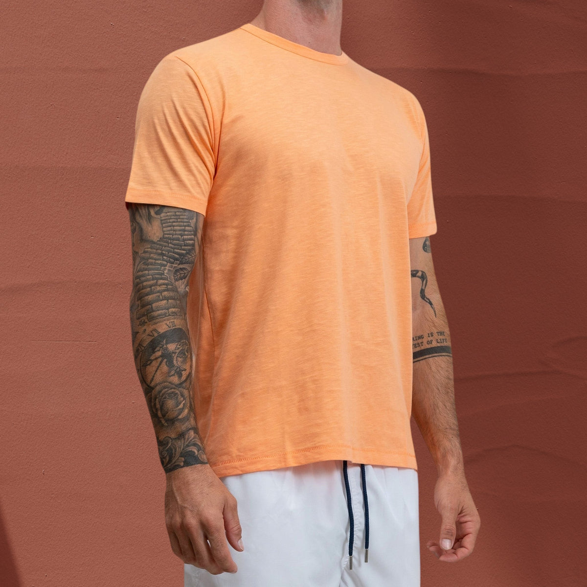 T-shirt Jasper St Barth French West Indies en coton flammé orange vif porté par un homme tatoué