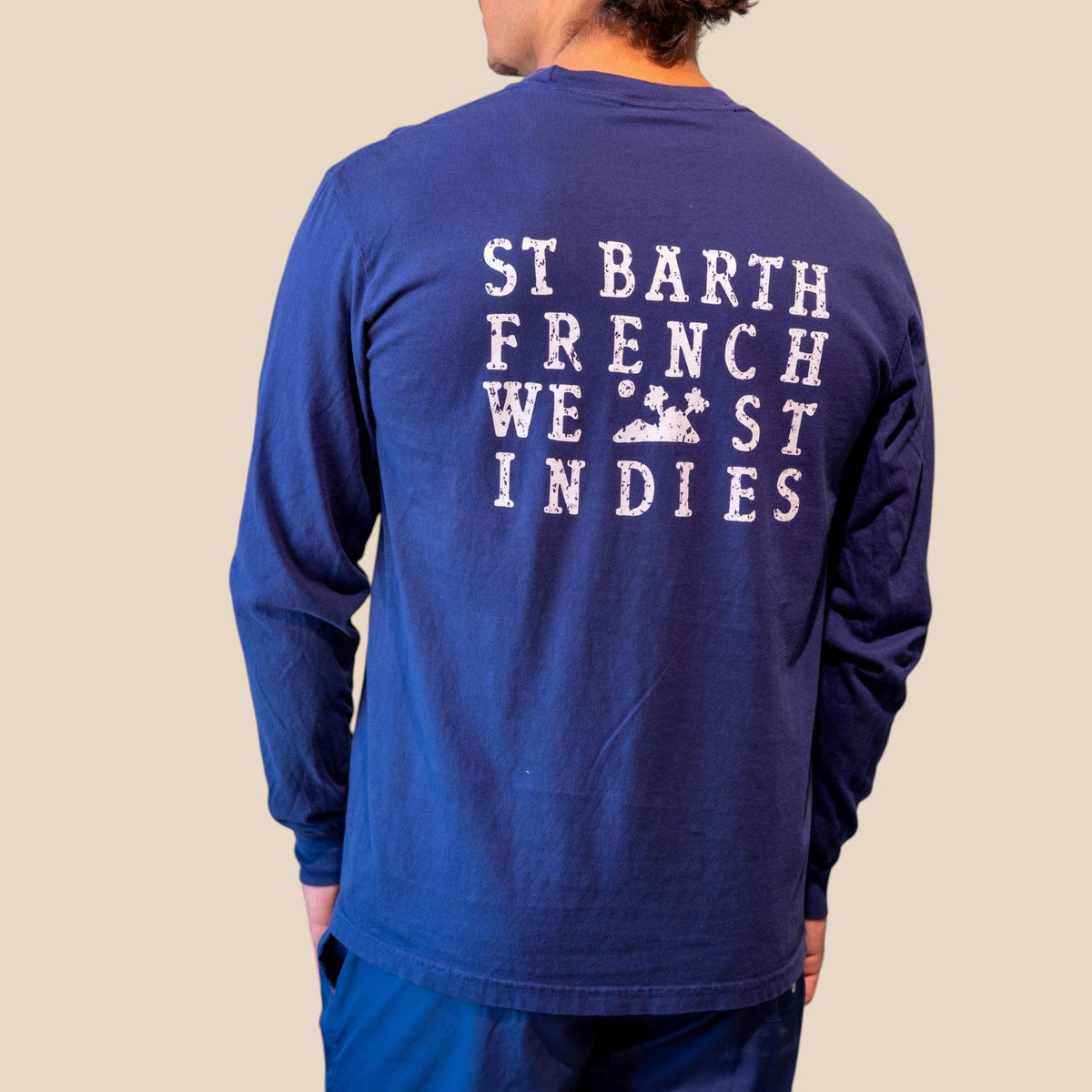 Homme portant un t-shirt bleu marine à manches longues St Barth French West Indies avec logo imprimé au dos