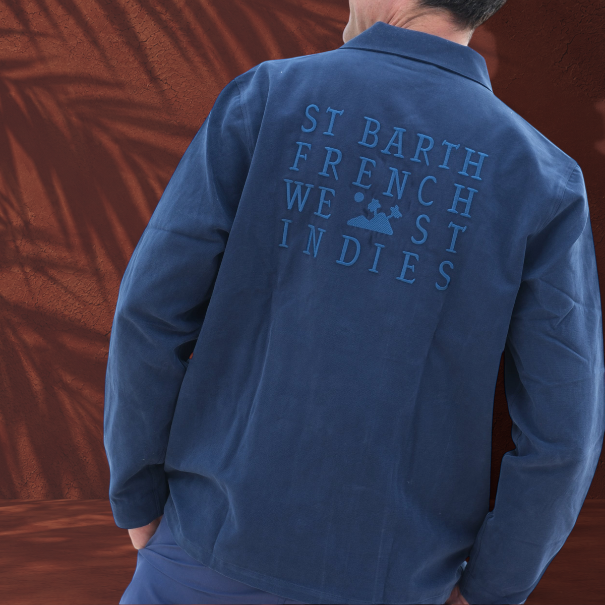Veste Jules St Barth French West Indies en sergé de coton bleu avec broderie au dos, vue de dos sur un homme.