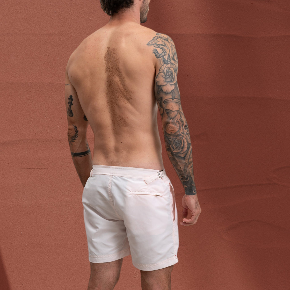 Homme portant un short de bain rose St Barth French West Indies avec attaches latérales chromées, vue arrière