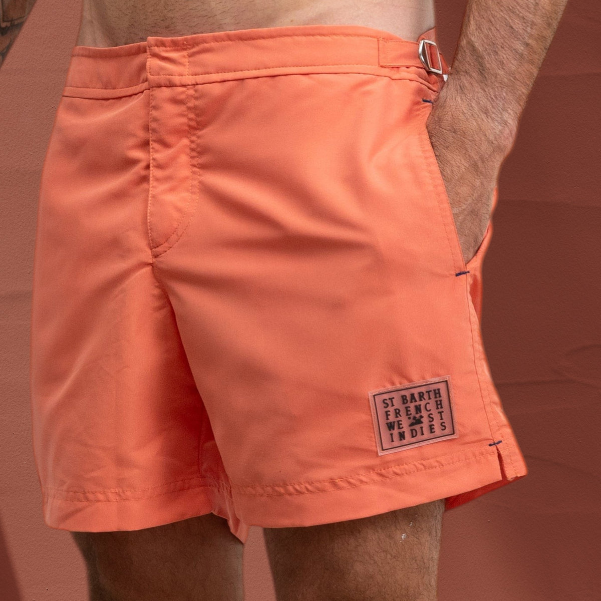 Homme portant un short de bain corail St Barth French West Indies avec fermetures latérales chromées et logo 3D