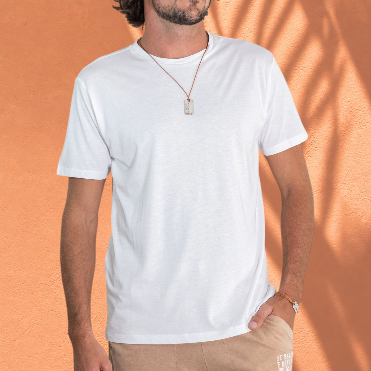 Homme portant un t-shirt blanc St Barth French West Indies Gustave en coton et modal avec un short beige