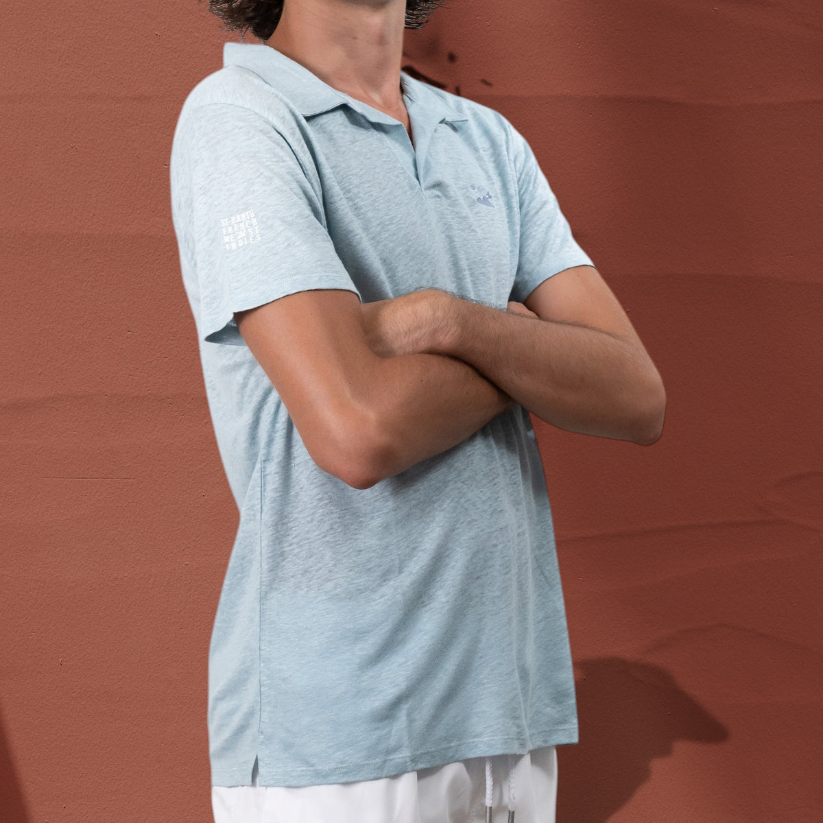 Homme portant un polo St Barth French West Indies en jersey de lin bleu clair avec broderie et logo sur la manche