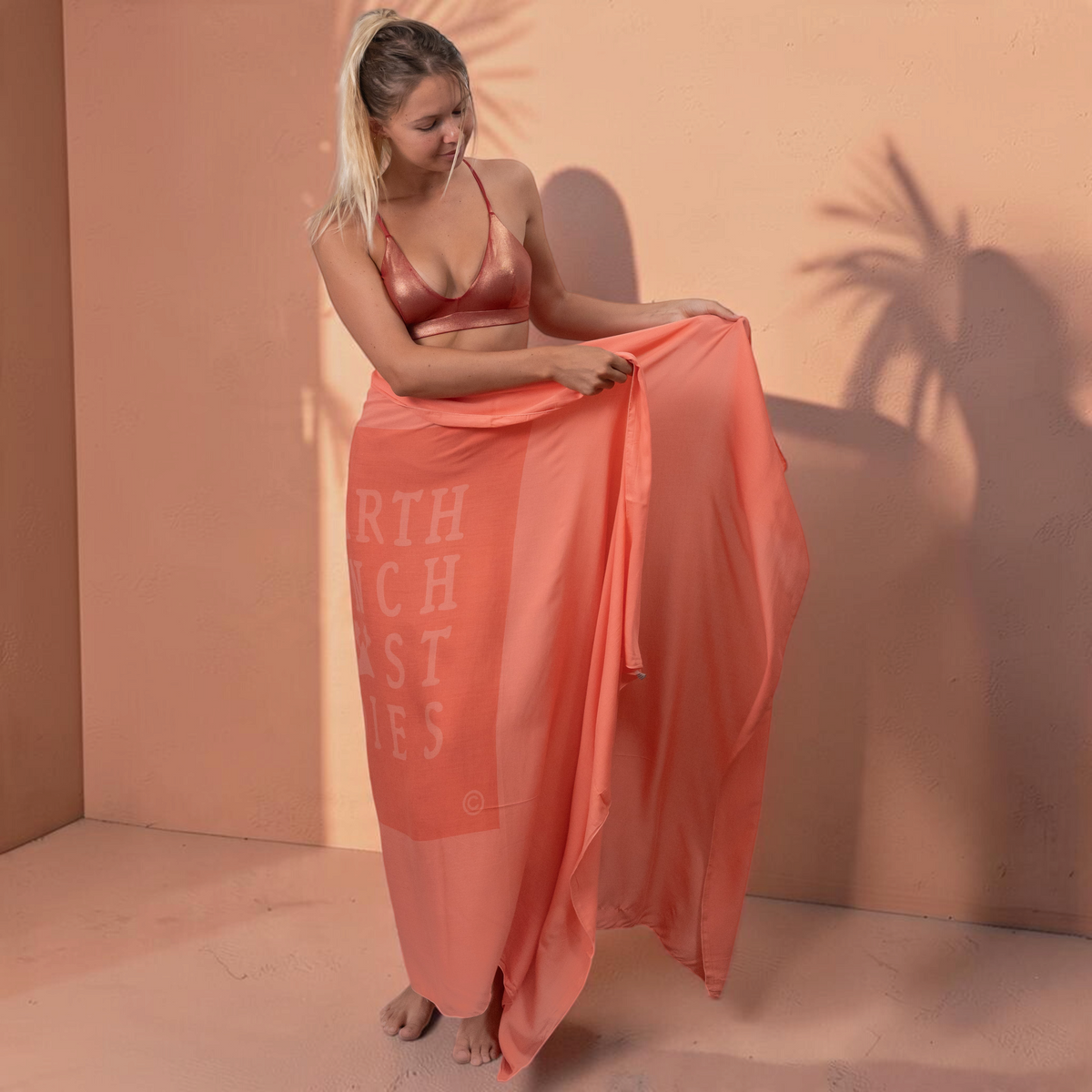 Femme portant un paréo St Barth French West Indies en voile de rayonne corail léger et doux noué à la taille