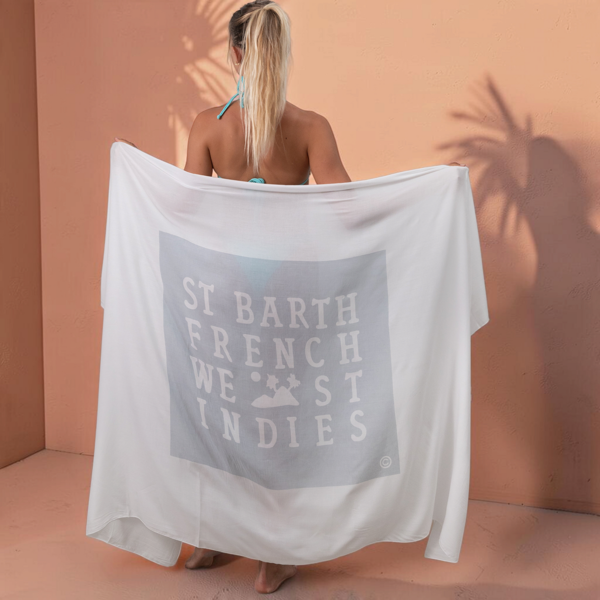 Femme portant un paréo blanc St Barth French West Indies en voile de rayonne doux avec logo imprimé au dos