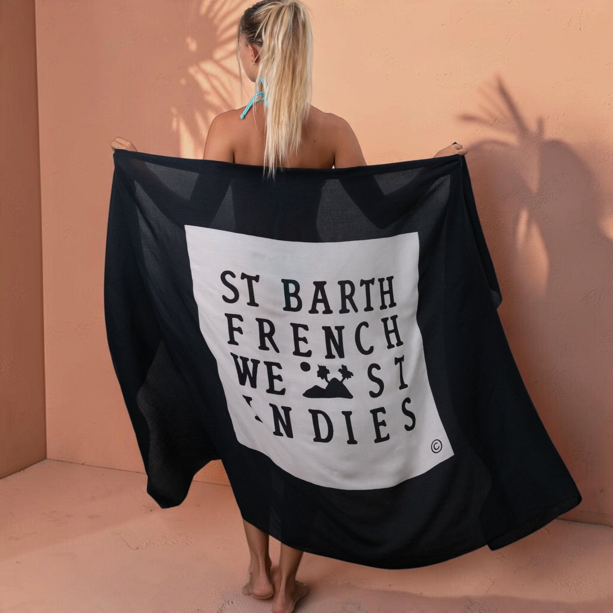 Femme portant un paréo St Barth French West Indies noir en voile de rayonne doux avec logo imprimé au dos
