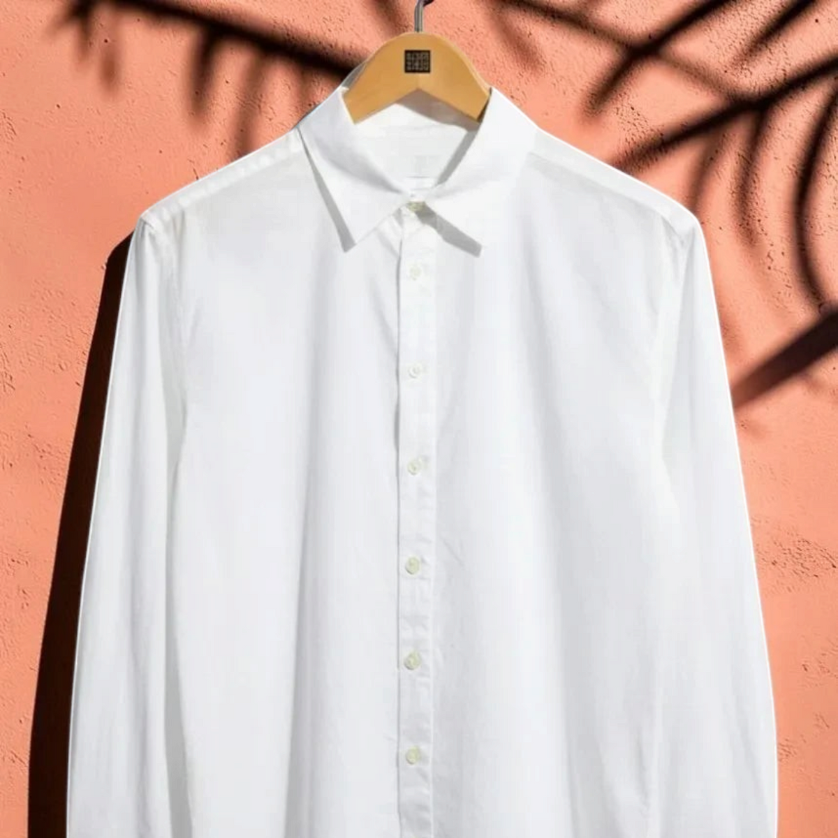 Chemise blanche légère en coton St Barth French West Indies à manches longues sur fond texturé corail