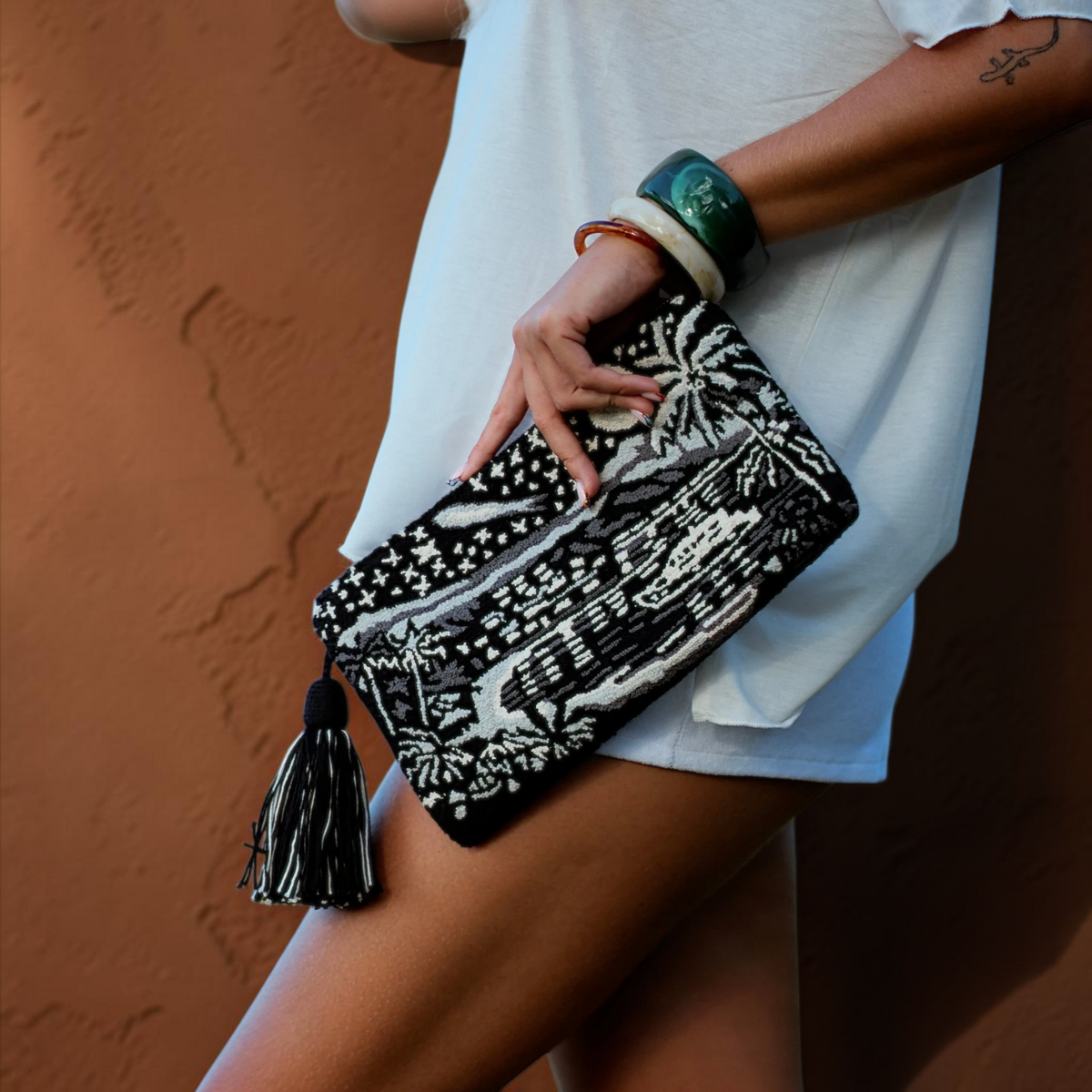 Pochette Mama Tierra St Barth French West Indies artisanale noire et blanche avec motif tropical et pompon