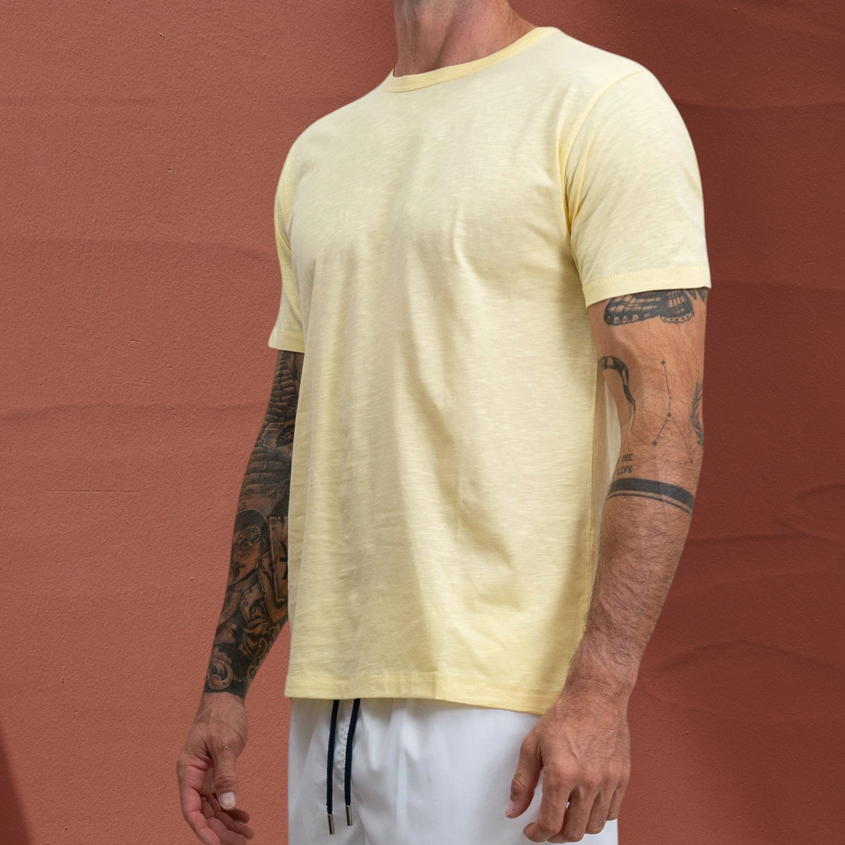 T-shirt Jasper St Barth French West Indies en coton flammé jaune pâle porté par un homme tatoué