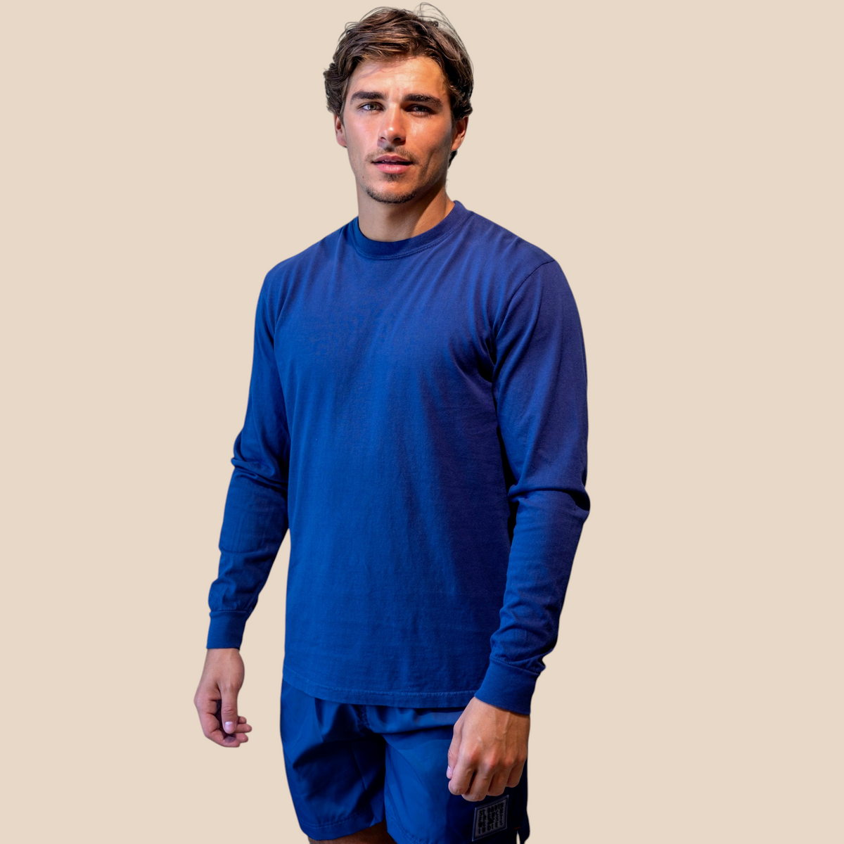 Homme portant un t-shirt à manches longues bleu St Barth French West Indies avec un short assorti