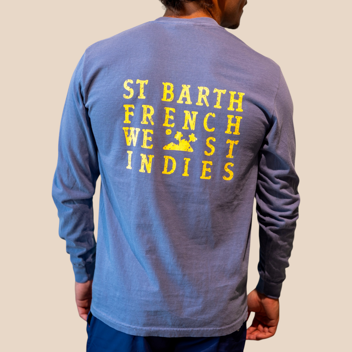 Homme portant un t-shirt à manches longues St Barth French West Indies bleu en coton avec logo jaune au dos