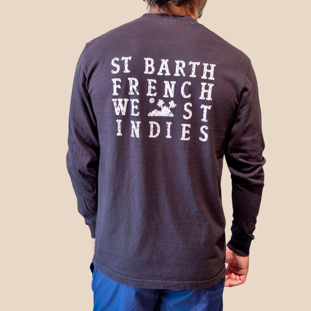 Homme portant un t-shirt à manches longues noir St Barth French West Indies avec logo blanc imprimé dans le dos