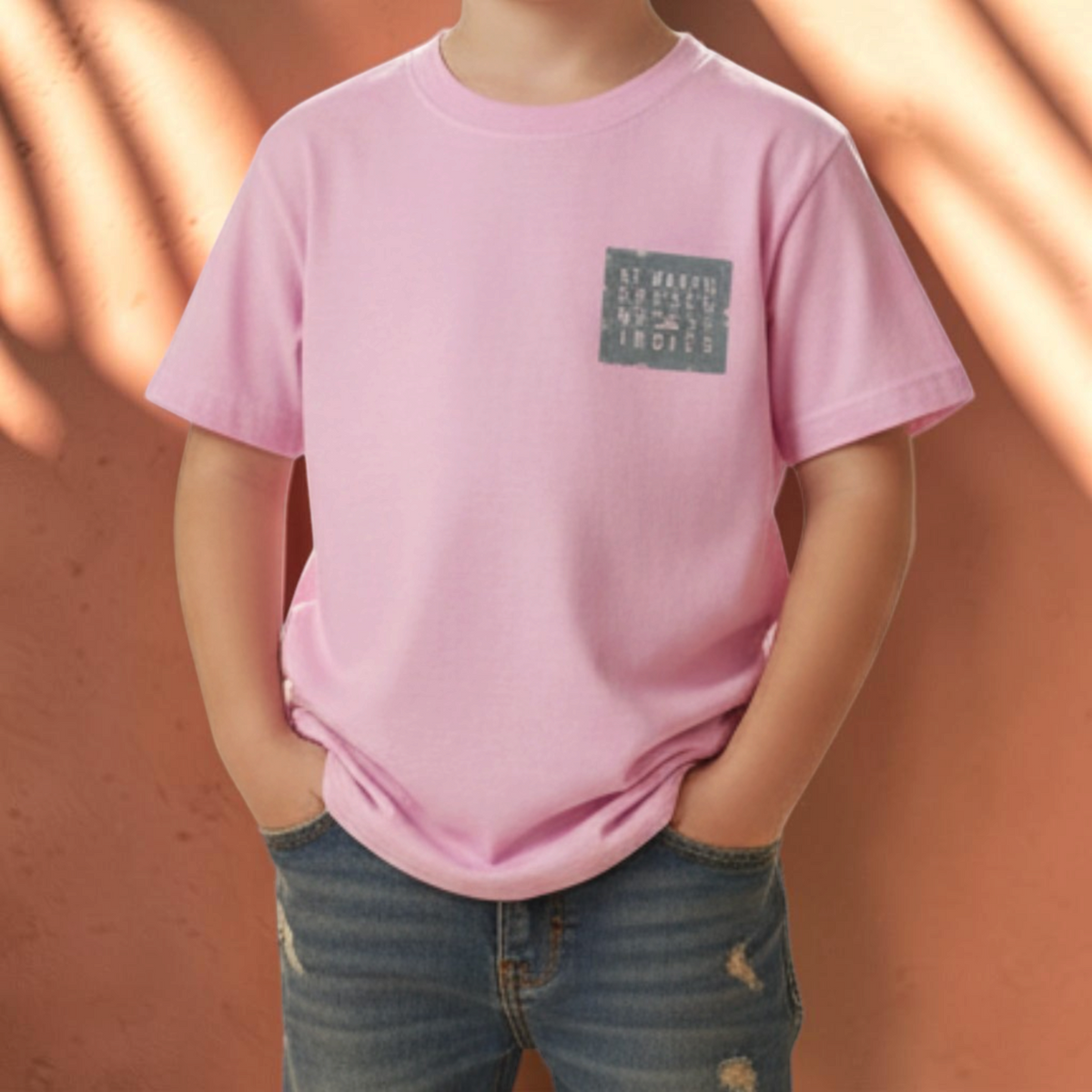 Enfant portant un t-shirt rose St Barth French West Indies avec un logo carré sur la poitrine et un jean bleu